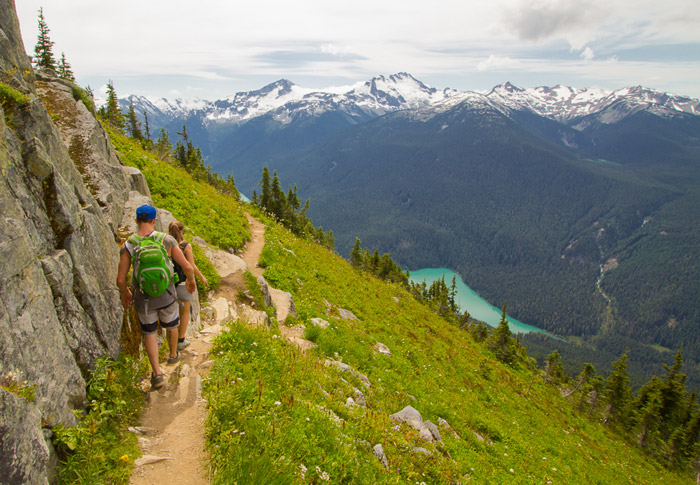 A couple is walking/hiking on the summit of Whisler Mountain in Canada.